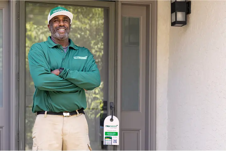 A friendly TruGreen customer service expert wearing a headset and smiling, ready to assist.